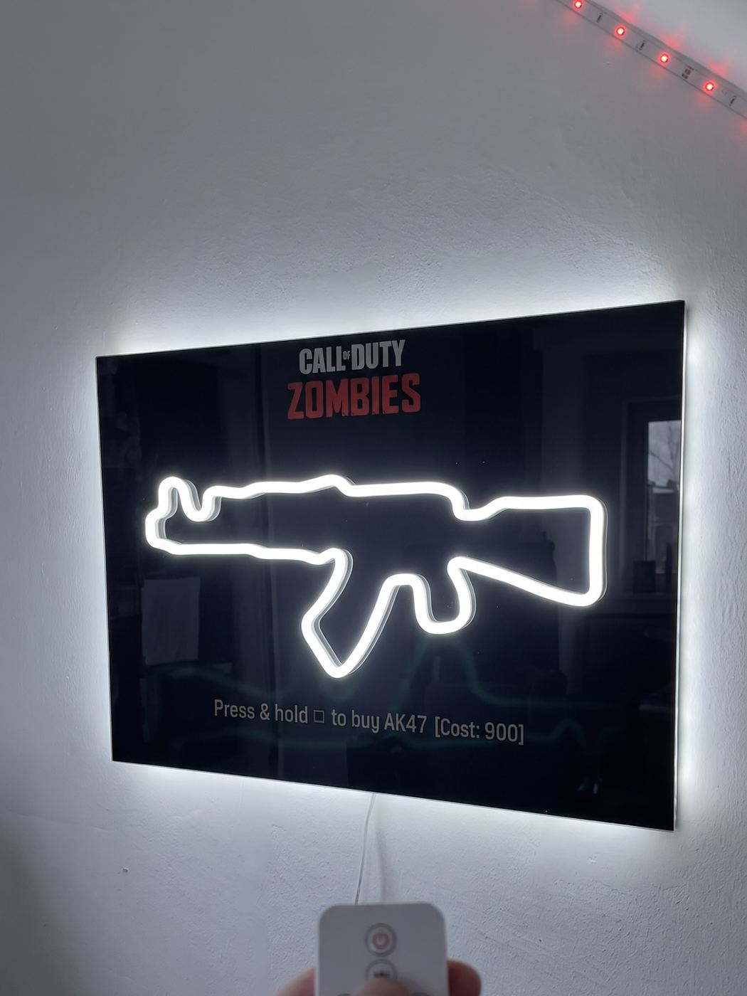 The same sign powered on — the AK-74u glowing white with a halo on the wall